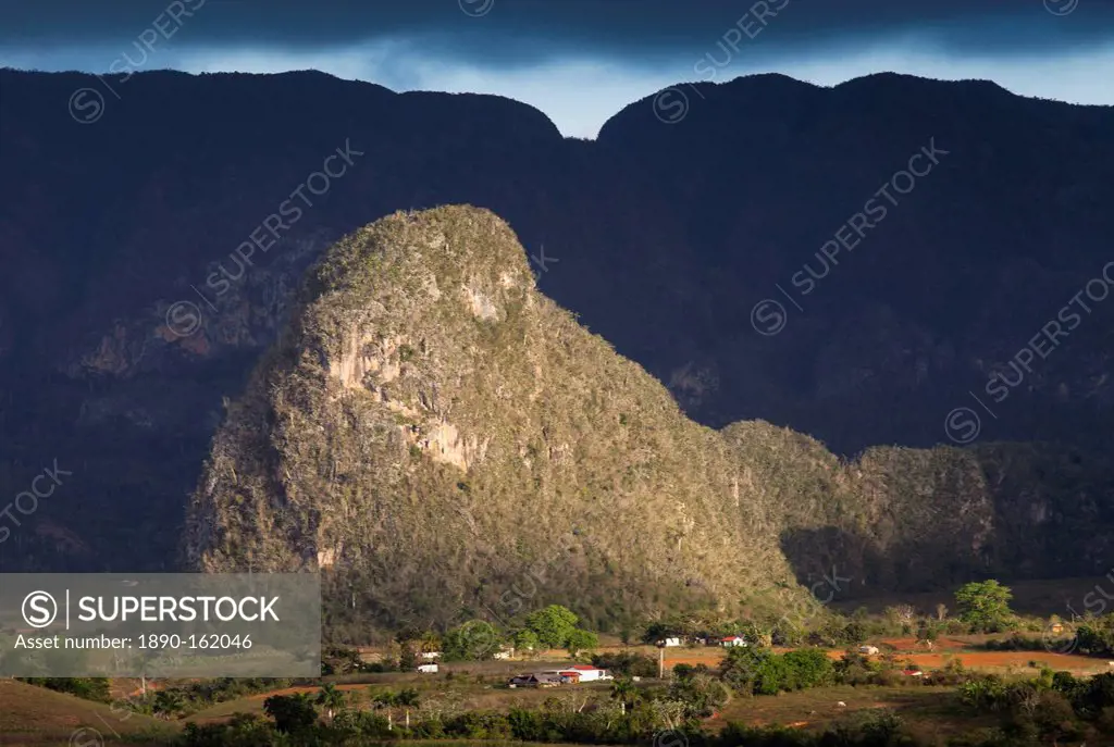 View across Vinales Valley, UNESCO World Heritage Site, from Hotel Los Jasmines in stormy weather showing one of the limestone Magotes lit by the sun ...