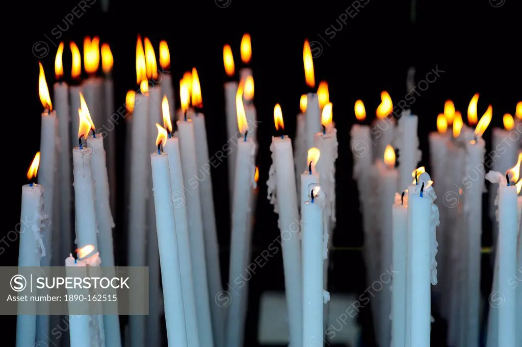 Altar candles in the Cave where Bernadette Soubirous had her Marian apparitions of our Lady of Lourdes in the French town of Lourdes, Hautes-Pyrenees,...