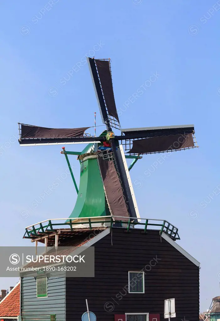 Preserved historic windmills and houses in Zaanse Schans, a village and working museum on the banks of the river Zaan, near Amsterdam, Zaandam, North ...