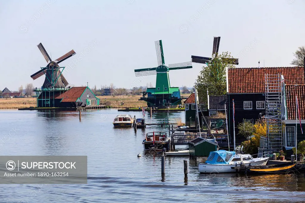 Preserved historic windmills and houses in Zaanse Schans, a village and working museum on the banks of the river Zaan, near Amsterdam, Zaandam, North ...