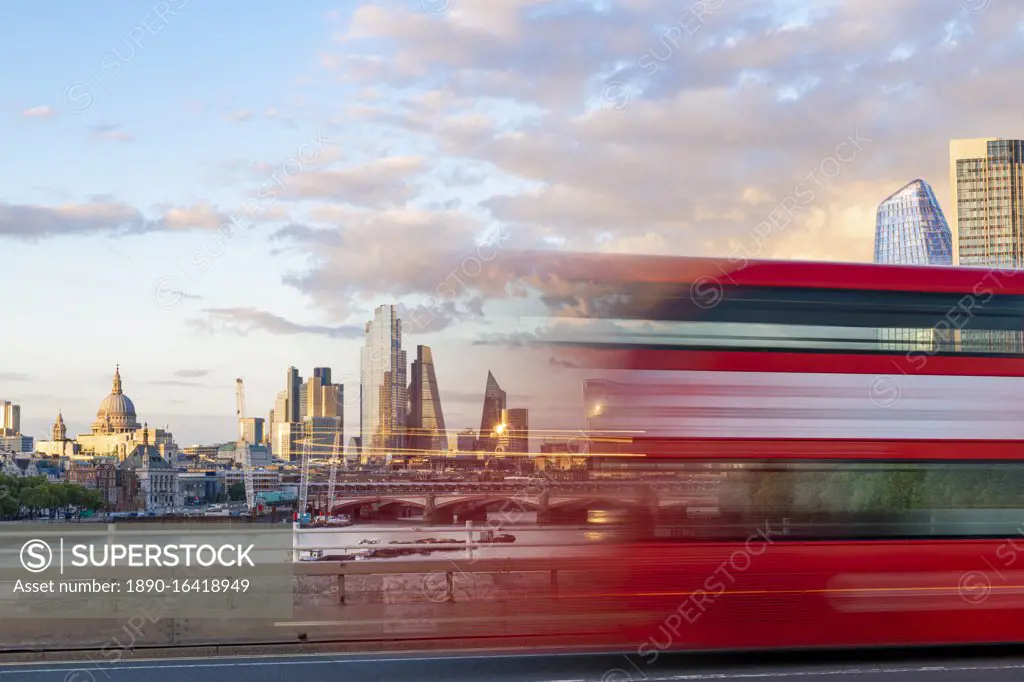 A red London bus goes past in a blur across Waterloo Bridge with the City of London and Southbank in distance, London, England, United Kingdom, Europe