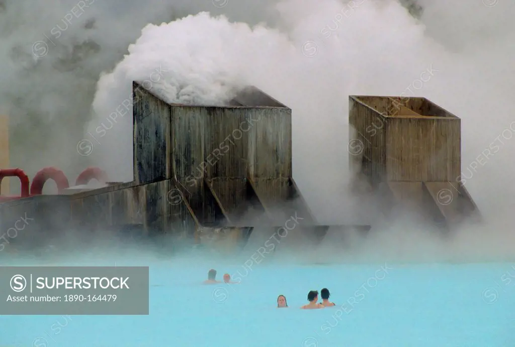 Clouds of steam rise as people swim in the Blue Lagoon thermal pool, Iceland
