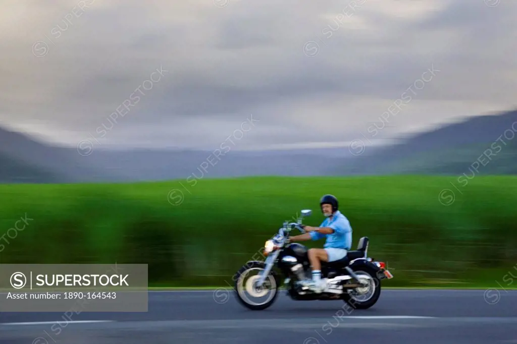 Motorcyclist passes sugar cane field at Freshwater Connection, Australia