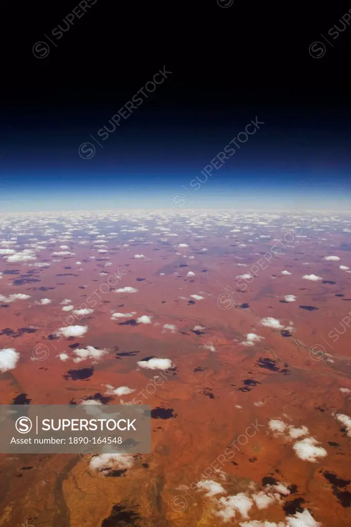 Red Centre viewed from aeroplane showing clouds and red earth over central Australia