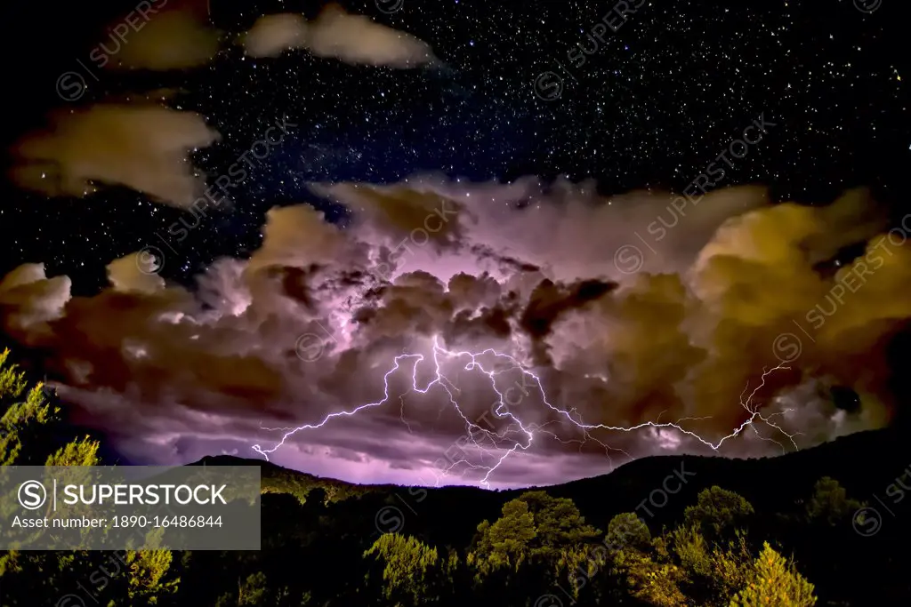 A storm approaching Sullivan Butte in Chino Valley at night with a starry sky above, Arizona, United States of America, North America