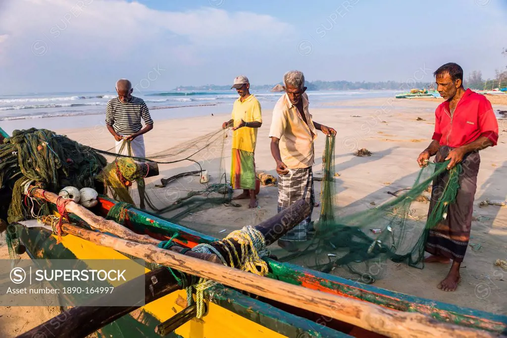 Fishermen sorting their catch on Weligama Beach, South Coast of Sri Lanka, Asia