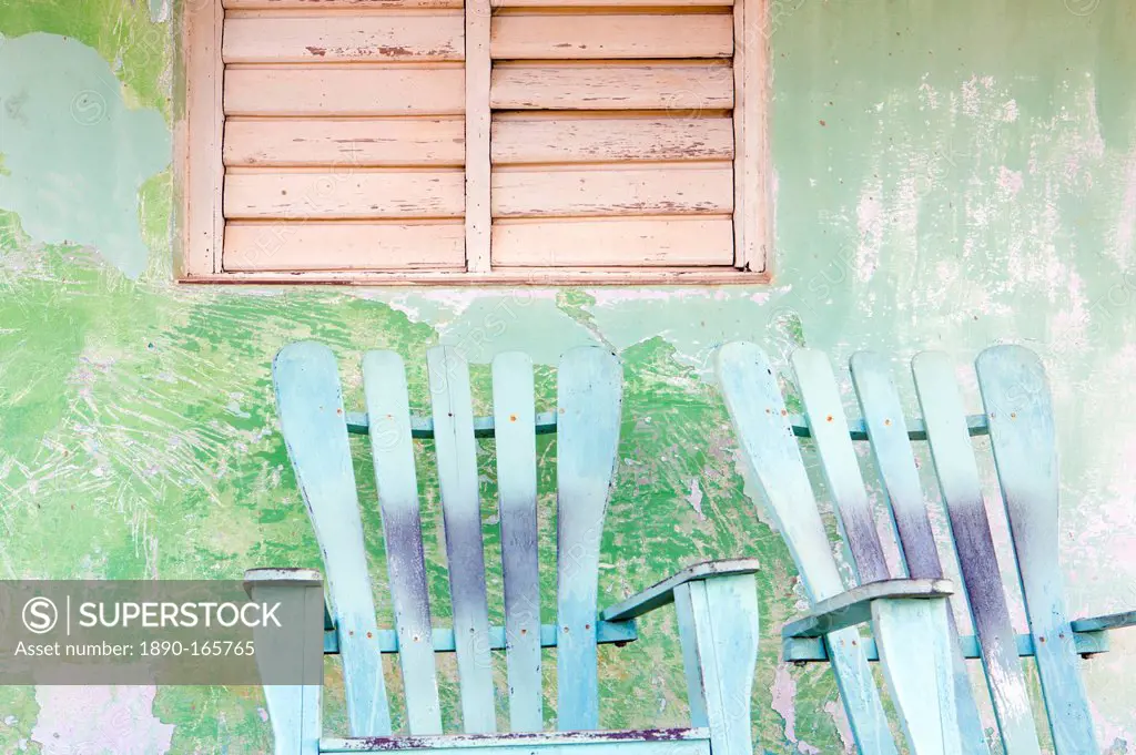 Detail of wall and rocking chair with faded paintwork in green and blue, a common sight in the small town of Vinales, Pinar Del Rio Province, Cuba, We...