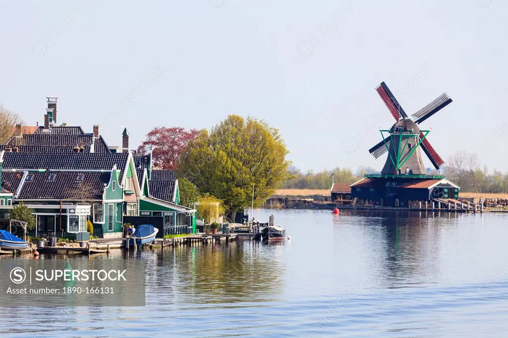 Preserved historic windmills and houses in Zaanse Schans, a village on the banks of the River Zaan, near Amsterdam, a tourist attraction and working m...