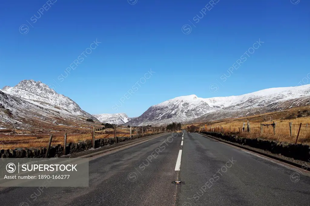 The A5 road runs through past snow-capped mountains in Snowdonia National Park, Wales, United Kingdom, Europe