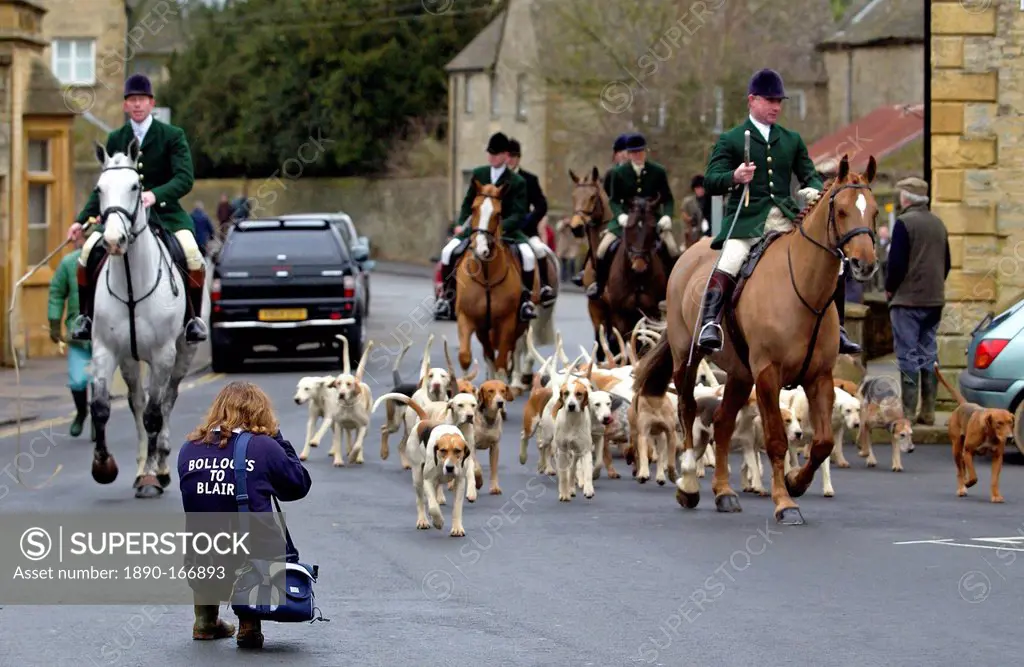 Huntsmen arriving at the Market Place, Stow-on-the-Wold, for a meet for the Heythrop New Year's Day Hunt, Oxfordshire. Woman crouches to take a pictur...