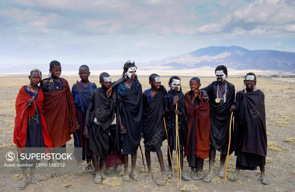 Young recently circumcised Masai Warriors (moran) with traditional face paint after 'coming of age', and young Masai girls, in the Serengei Plains, Ta...