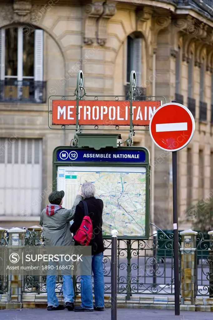 Tourists on foot study Metropolitain subway map for the Paris Metro in Rue du Bac, Left Bank, Paris, France