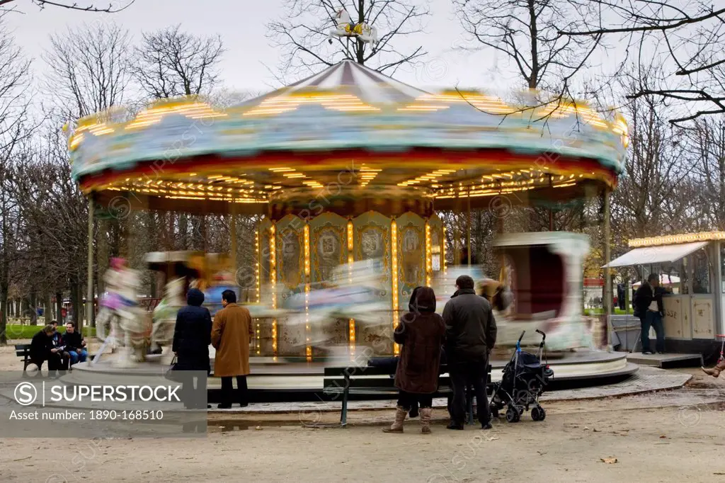 Parents watch their children on the carousel in Jardin des Tuileries, Central Paris, France
