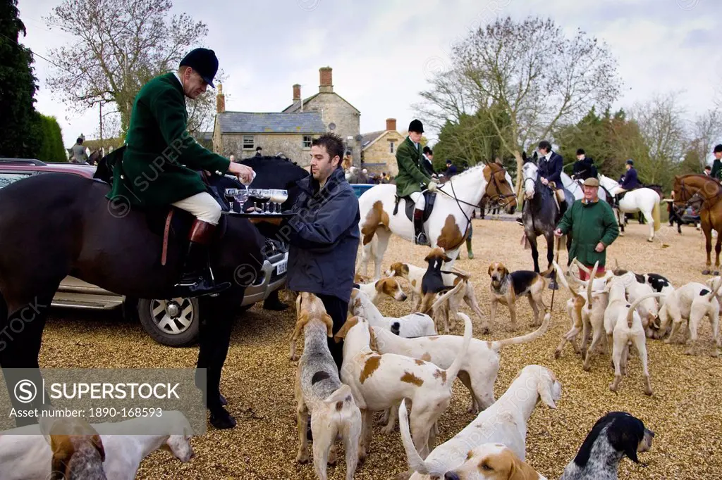 Members of Heythrop Hunt are offered traditional stirrup cup drinks at hunt meet, The Cotswolds, Oxfordshire