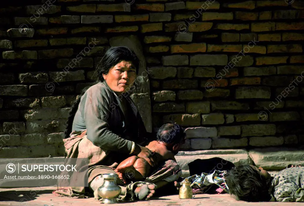 A woman cradles her baby in the streets, Nepal, Asia