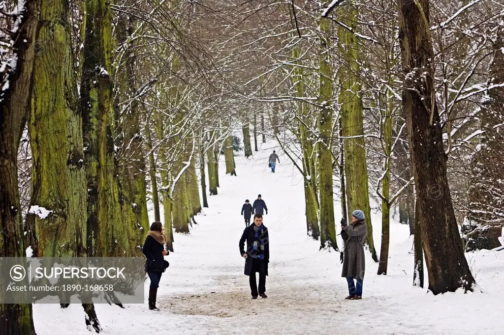 People walk across snow-covered Hampstead Heath, London, United Kingdom