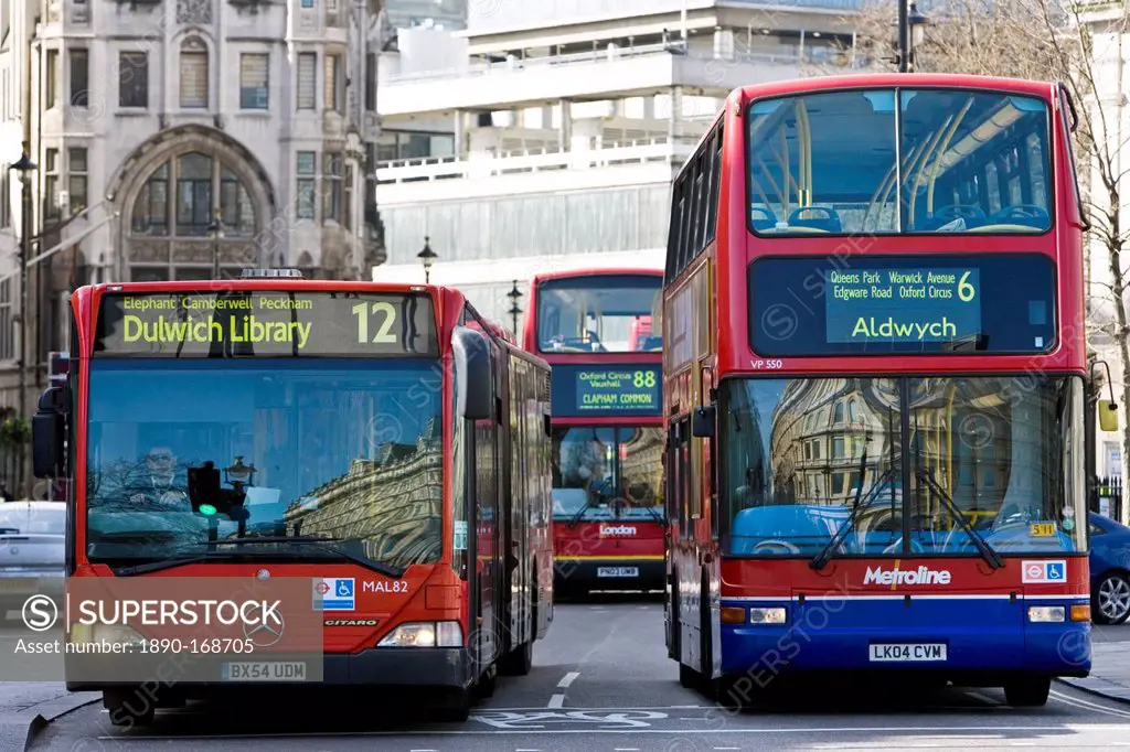 Public transport buses travel in heavy traffic in Trafalgar Square, London city centre, England, United Kingdom