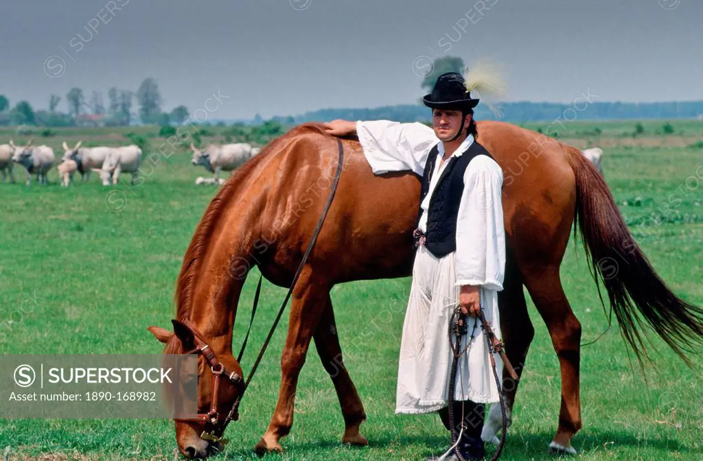 Traditional Csikos Cowboy with his horse on the Great Hungarian Plains in Bugac, Hungary.