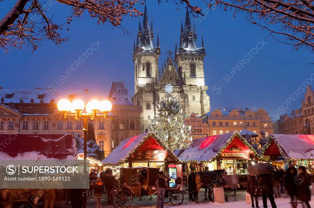 Merry Christmas sign at snow-covered Christmas Market and Tyn Church, Old Town Square, Prague, Czech Republic, Europe