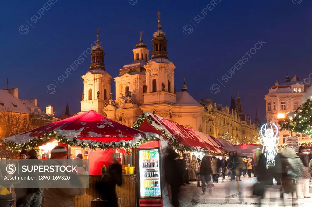 Snow-covered Christmas Market and Baroque St. Nicholas Church, Old Town Square, Prague, Czech Republic, Europe