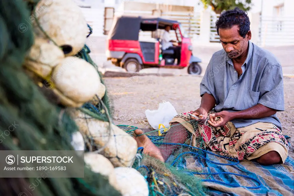 Portrait of a fisherman mending his fishing nets in Negombo, West Coast, Sri Lanka, Asia