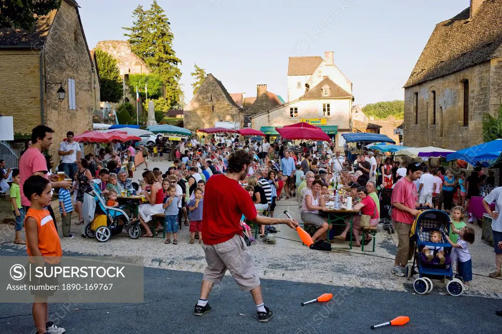 Juggler at village fete traditional festival in St Genies in the Perigord region, France