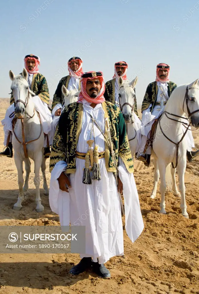 Bedouins with horses in the desert in Saudi Arabia