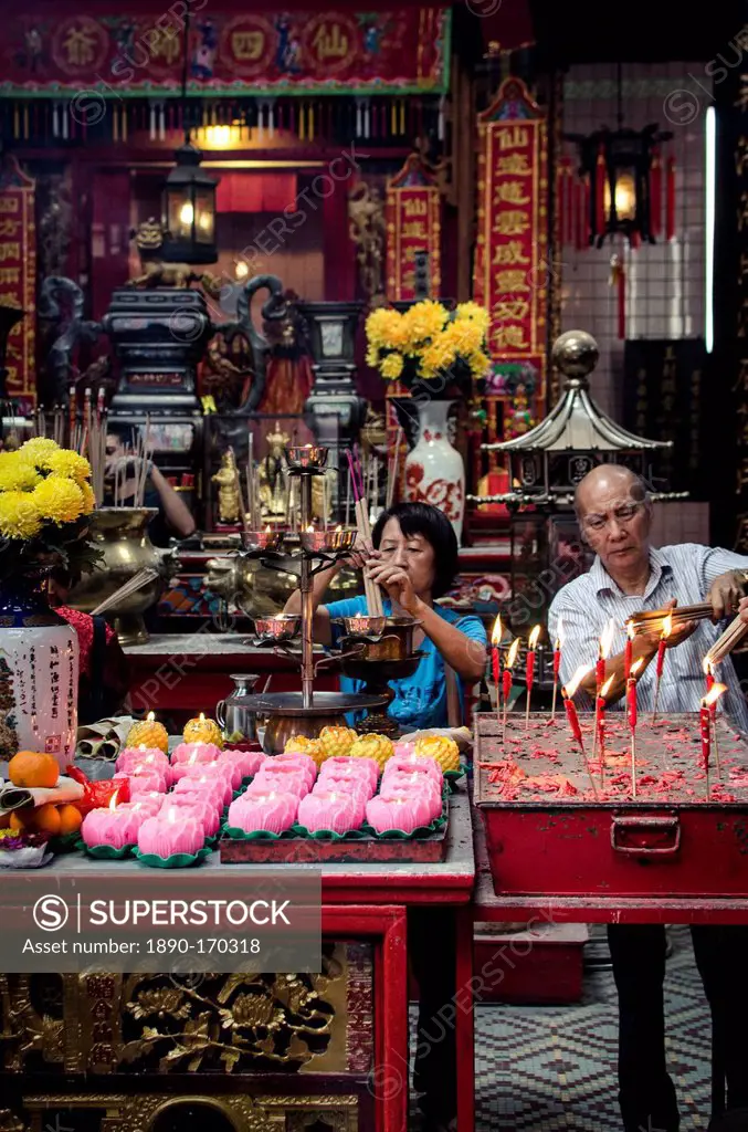A man and women light incense sticks during Chinese New Year celebrations, Sze Ya Temple, Chinatown, Kuala Lumpur, Malaysia, Southeast Asia, Asia