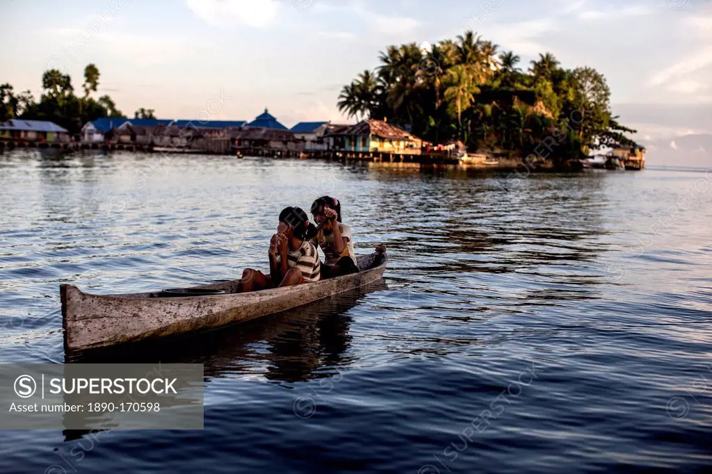 Two girls in a canoe, Togian Islands, Sulawesi, Indonesia, Southeast Asia, Asia
