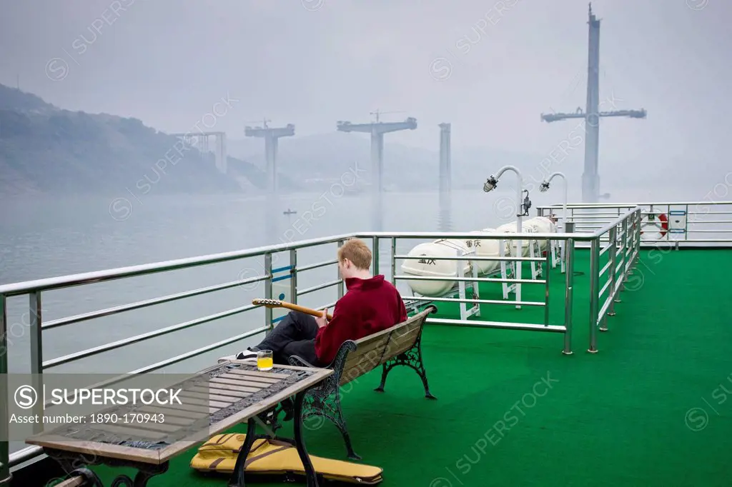 Tourist plays guitar on deck of Victoria Line Cruise Ship, Yangtze River, China