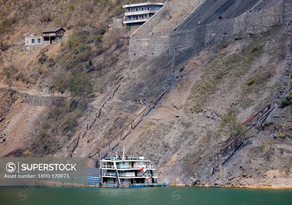 Coal slides down hillside to fill freight ship, in Three Gorges area, Yangtze River, China