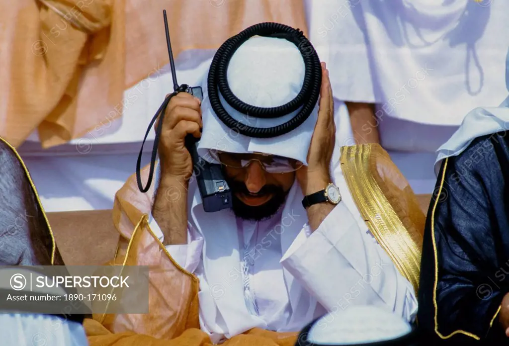 Arab using two-way radio to communicate during parade of armed forces in Abu Dhabi, United Arab Emirates