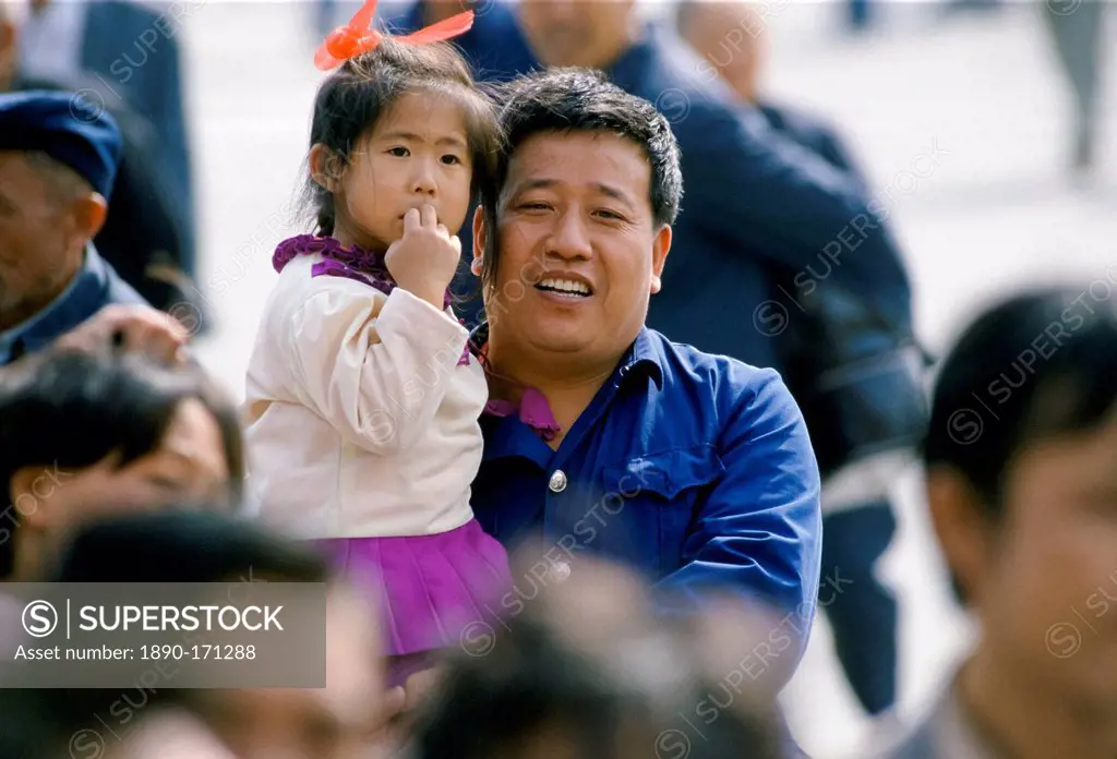 Chinese father and child among the crowds in Tiananmen Square in Peking, now Beijing, China in the 1980s