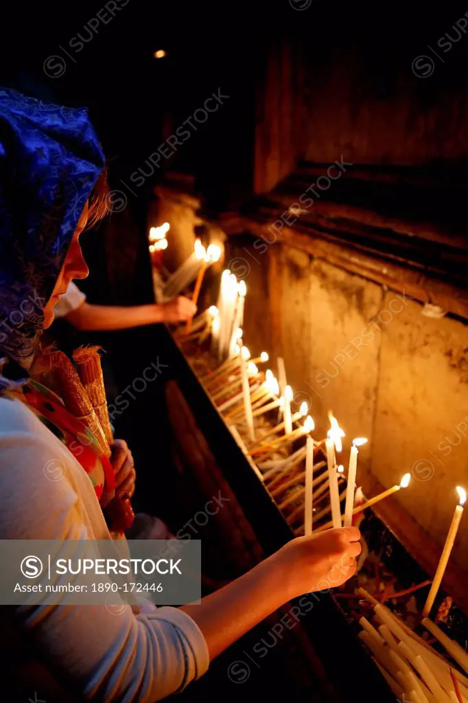 Pilgrims lighting candles in the Holy Sepulchre Church, Jerusalem, Israel, Middle East