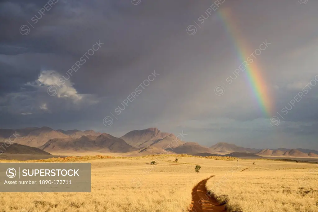 Storm clouds and rainbow in the early evening in NamibRand Nature Reserve, Namib Desert, Namibia, Africa