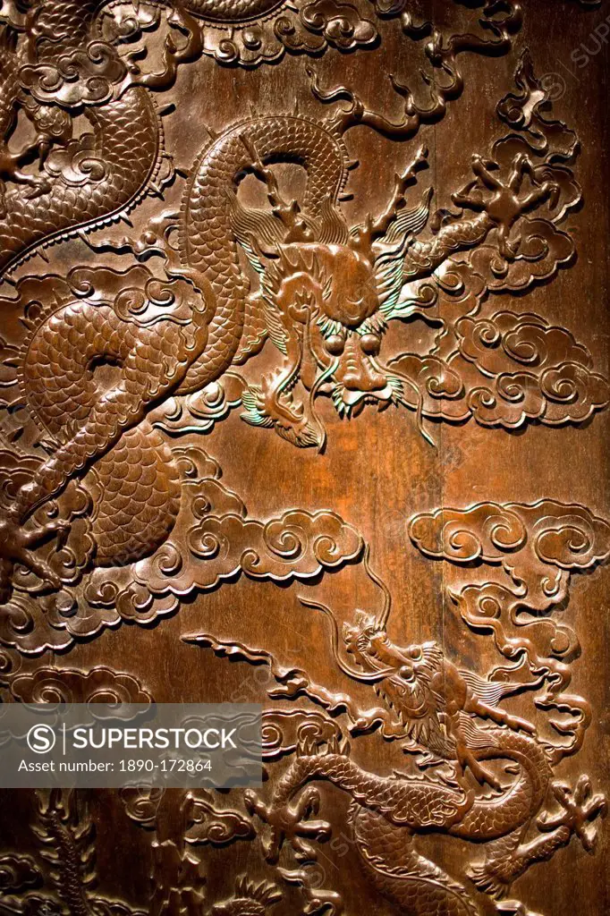 Qing Dynasty cabinet with engraved dragons and clouds design on display in the Shanghai Museum, China