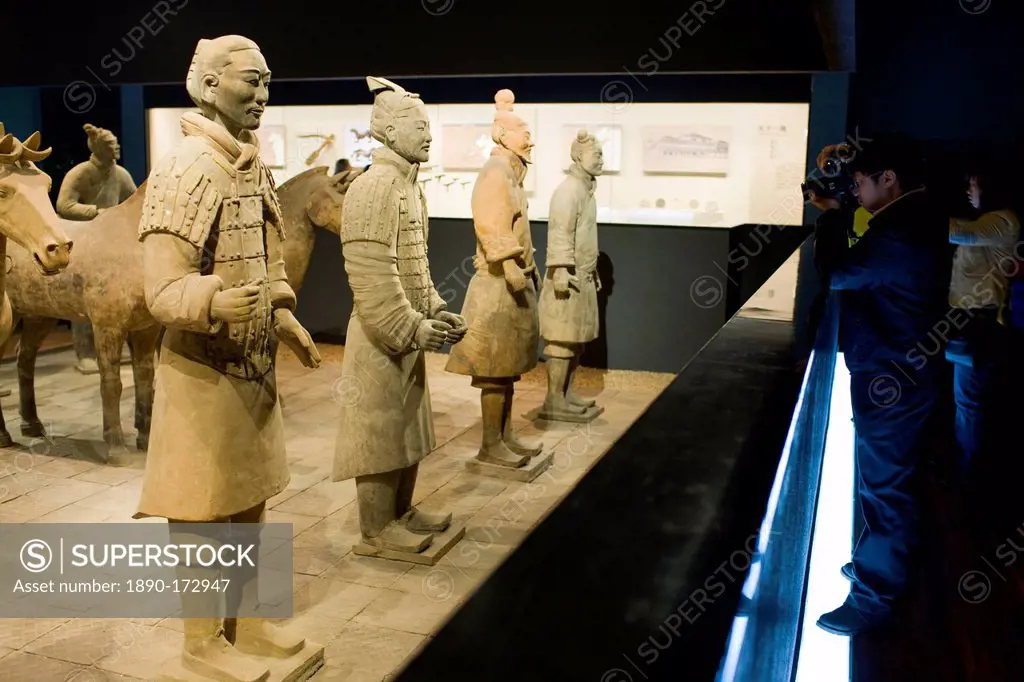 Tourist photographs Terracotta warriors on display in the Shaanxi History Museum, Xian, China