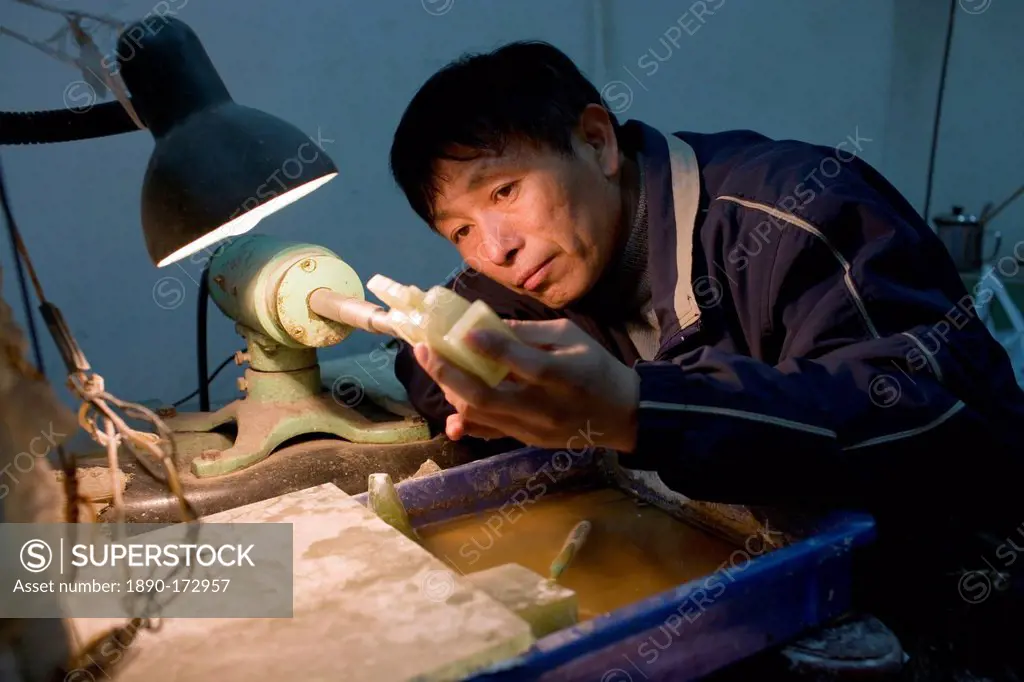 Jade craftsman at work in the Huahui Jade Factory and Showroom, Xian, China