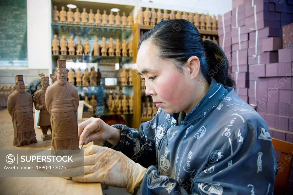 Woman makes Terracotta Warrior souvenirs in factory, Xian, China