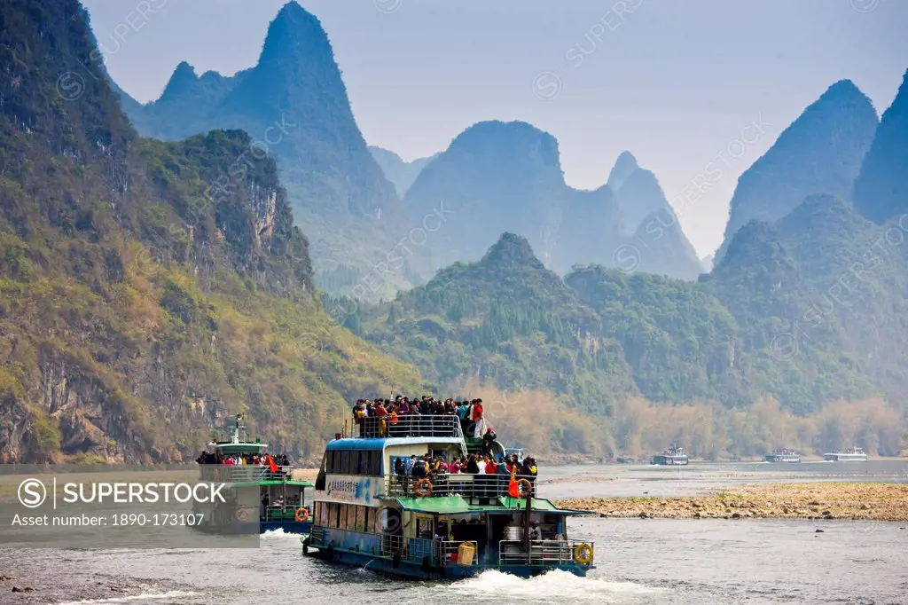 Tourist boats travel along Li River between Guilin and Yangshuo, China