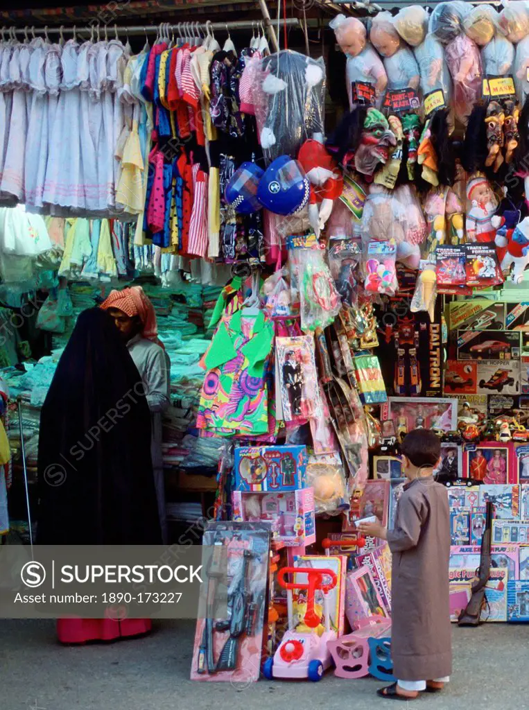 Small child gazing at toys in the market, Kuwait