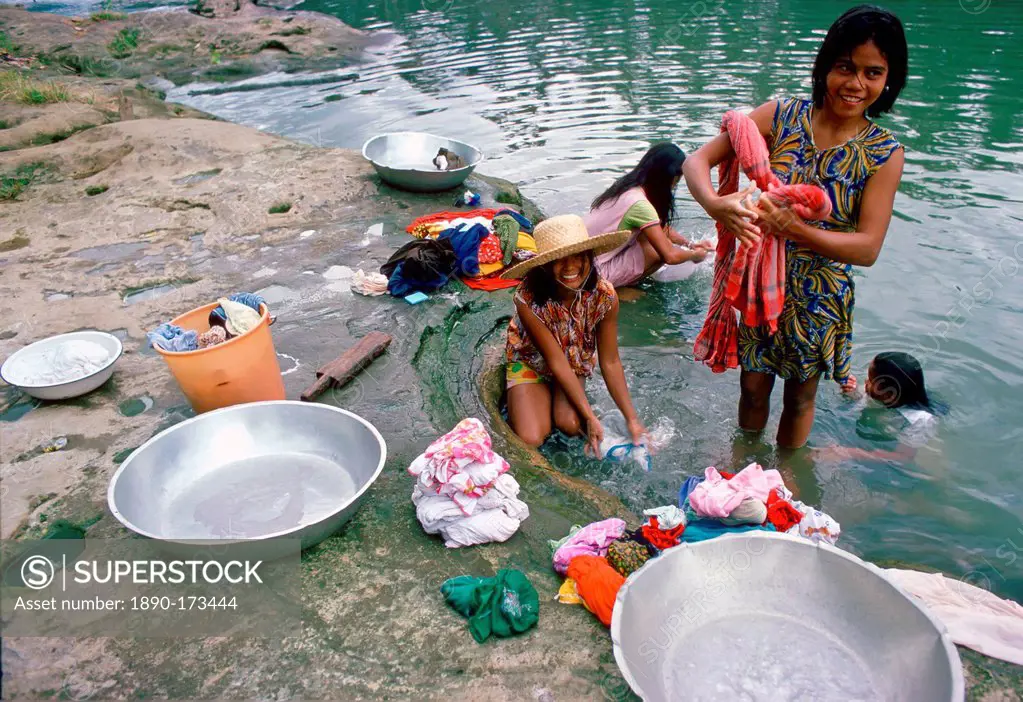 Girls washing clothes in a river, Philippines
