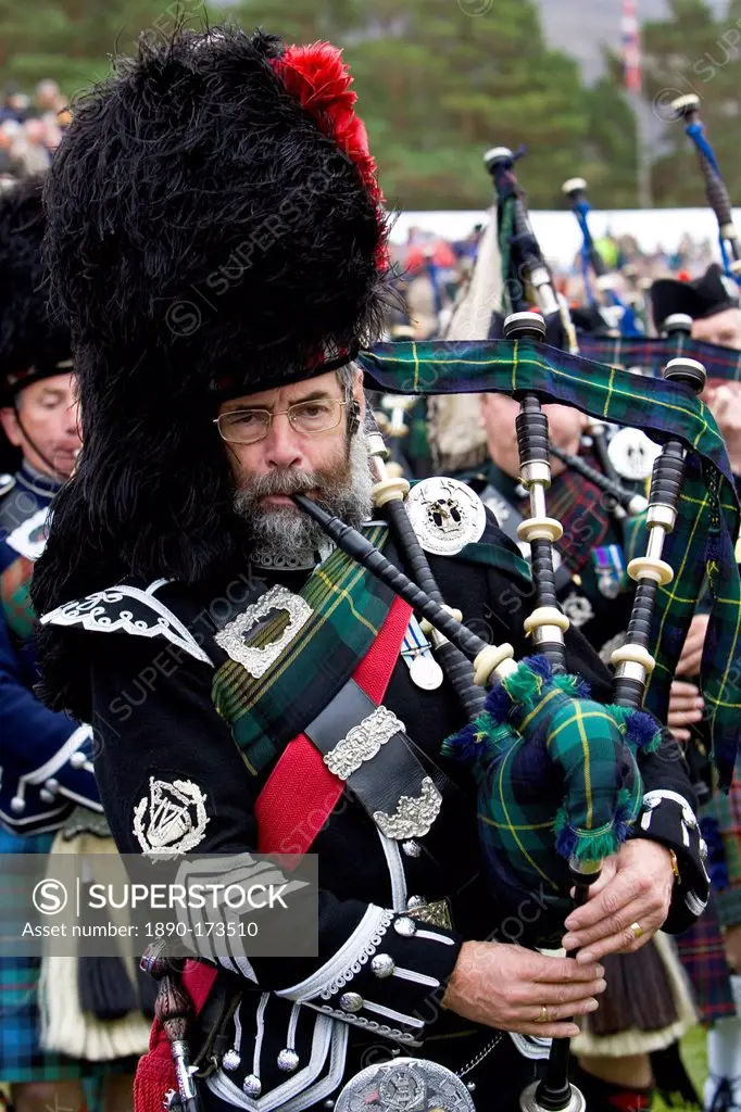 Bagpipe player of massed band of Scottish pipers at Braemar Games Highland Gathering, Scotland