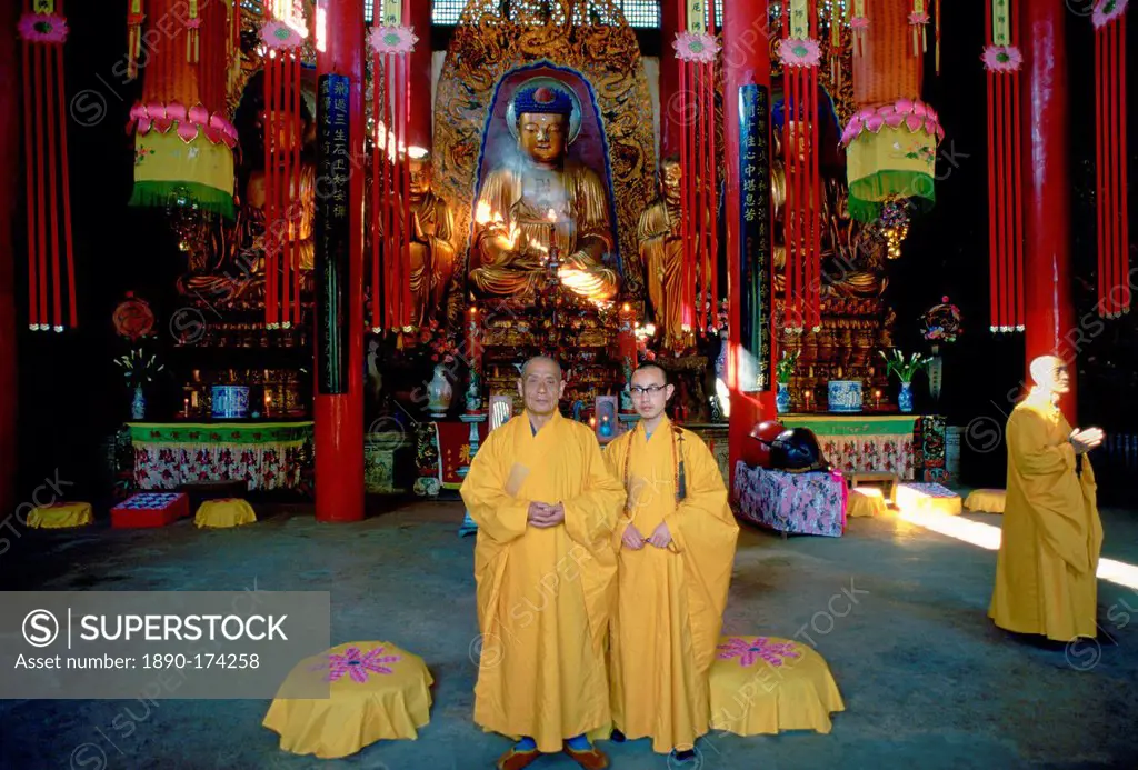 Buddhist monks in saffron coloured robes at the Buddhist Temple in Huating, Kunming, China