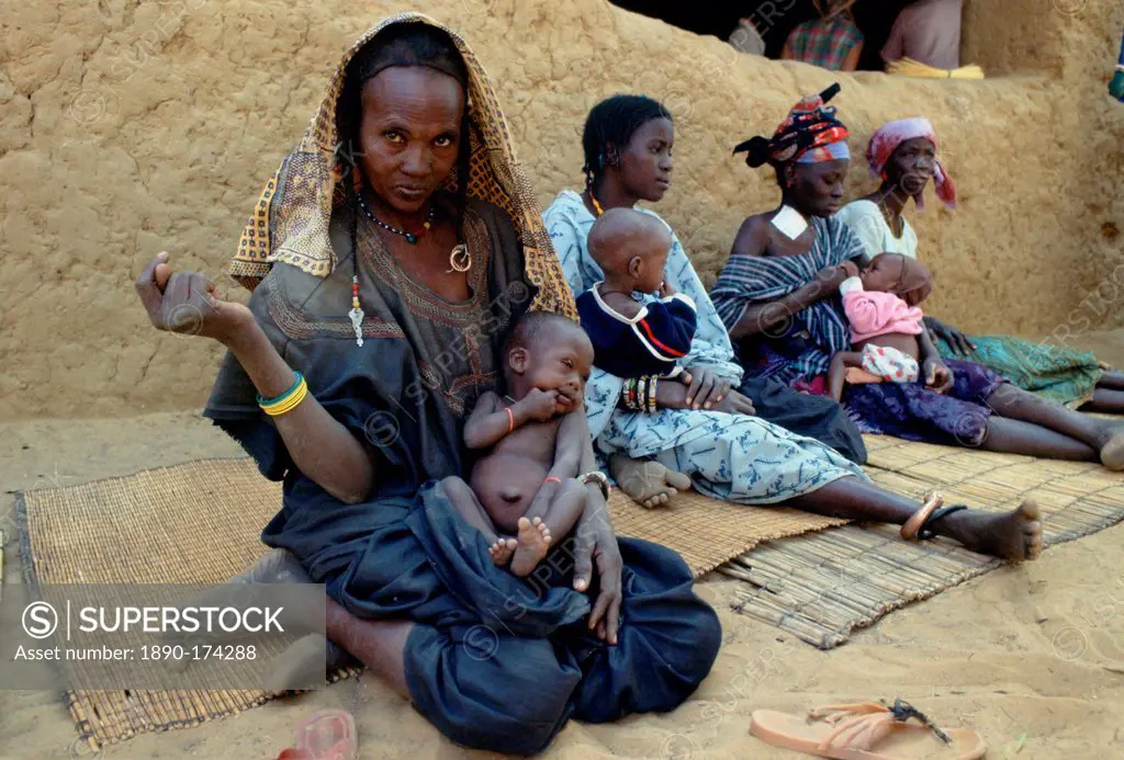Mothers and children sitting on mats while waiting at Gorom Gorom Hospital in Burkina Faso (formerly Upper Volta)