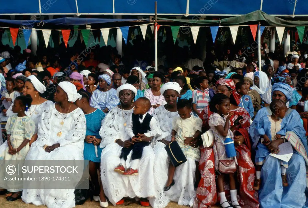 Gambians smartly dressed sitting with their children while watching an Independence Day parade in Banjul, The Gambia, West Africa.