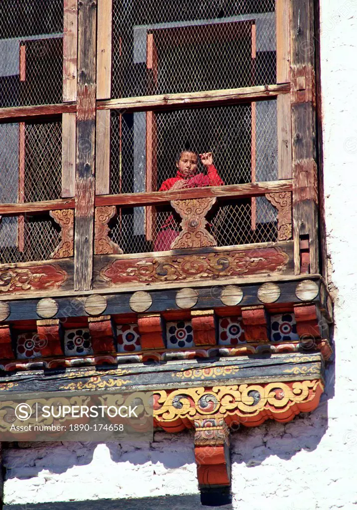 Child watching from carved decorative window, Thimpu, Bhutan