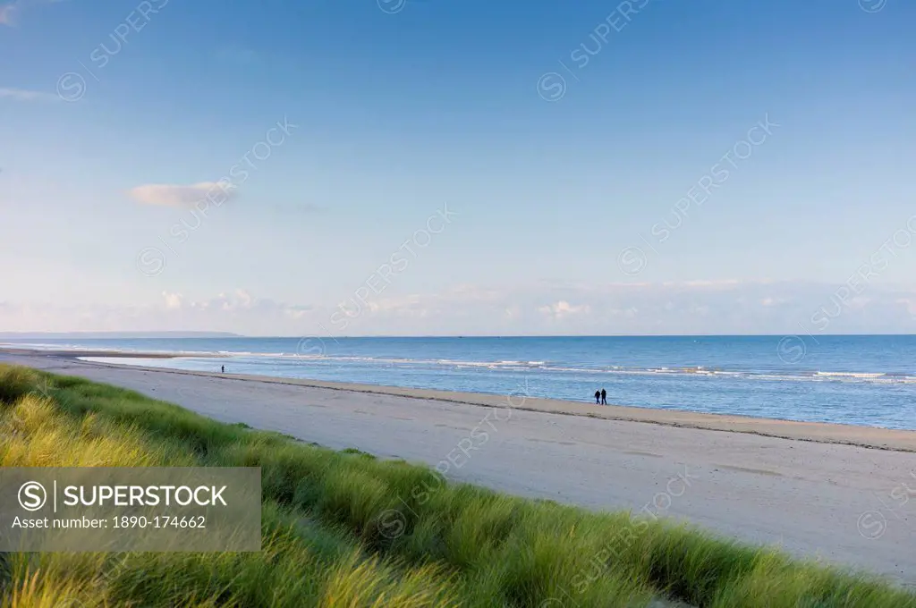 Couple stroll along deserted and peaceful Utah Beach, scene of the D-Day Landings, in Normandy, France