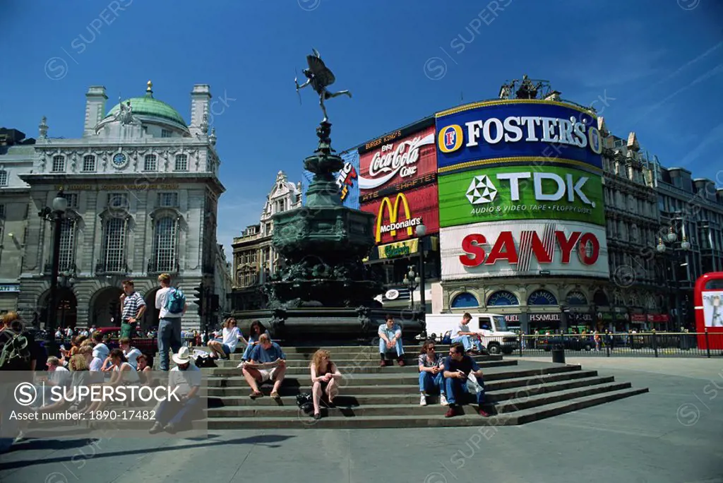 People sitting on steps below the Statue of Eros, Greek God of Love, erected in 1892 in memory of the Earl of Shaftesbury, Piccadilly Circus, London, ...