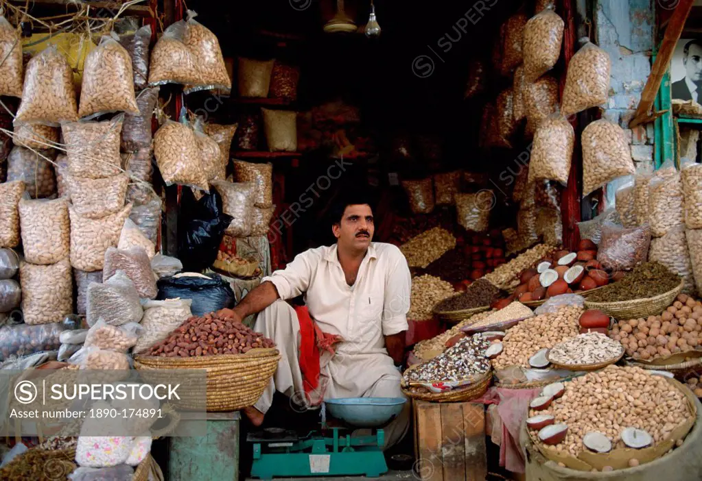 A man in Islamabad, Pakistan working in his shop selling fruit and nuts